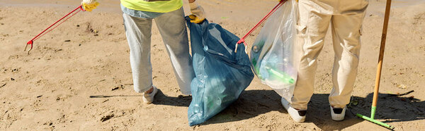 Социально активная любящая пара в защитных жилетах и перчатках стоит на песчаном пляже.