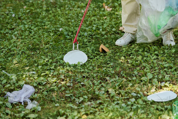 Трудолюбивый человек чистит траву в парке.