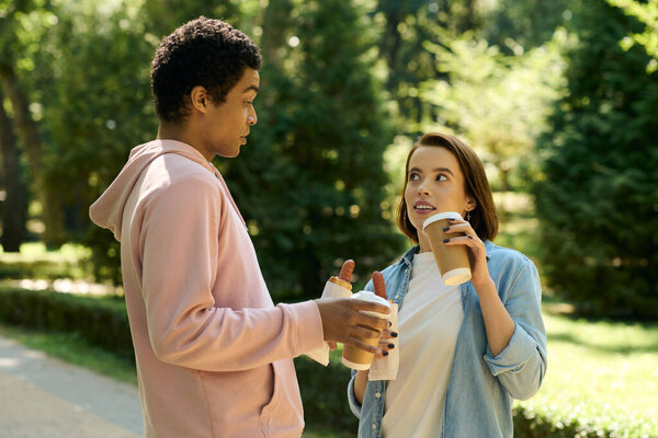 A couple in vibrant attire engages in a lively conversation outdoors, surrounded by the beauty of nature.