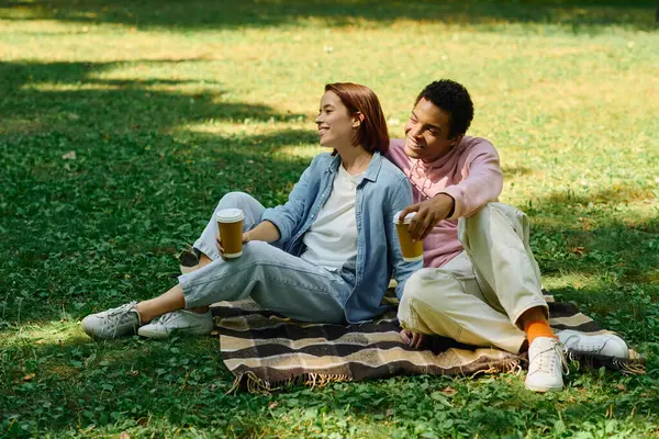 Diverse Couple Vibrant Attires Sitting Blanket Grass Enjoying Each Others —  Fotos de Stock