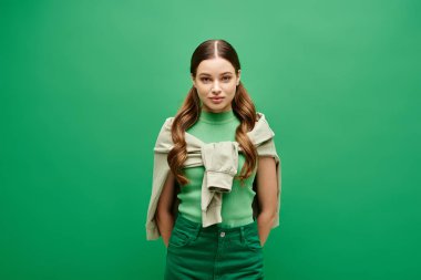 A young woman with long hair stands against a green background in a studio setting. clipart