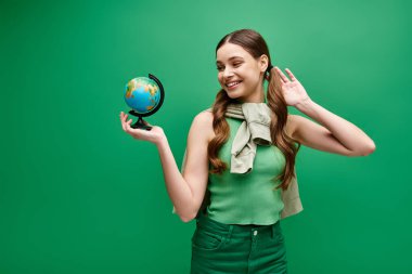 20 'li yaşlarda genç bir kadın elinde dünya ve küresel farkındalığı sembolize eden küçük bir küre tutuyor..