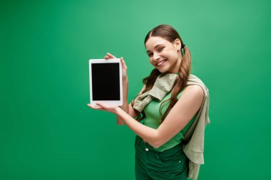 20 'li yaşlarda elinde tablet tutan genç bir kadın dijital dünyayla meşgul..