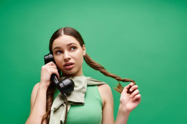20 'li yaşlarda genç bir kadın telefonu kulağına dayamış, bir sohbete dalmış..