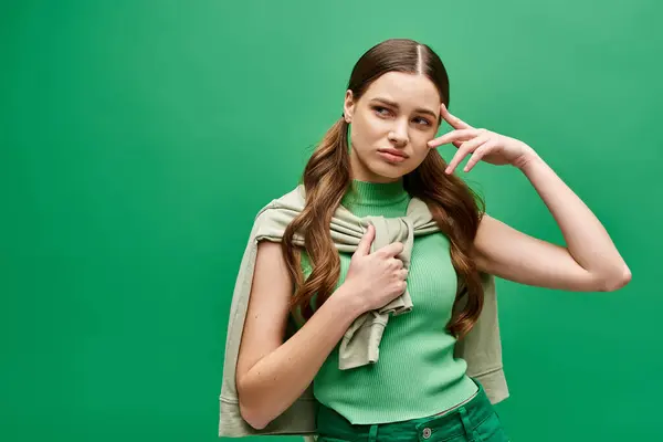 一位20多岁的年轻女子在一个充满活力的绿色背景前摆出一个姿势 — 图库照片