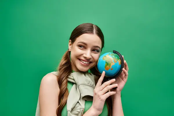 一位20多岁的年轻女子抱着一个小地球 象征着全球的团结和联系 — 图库照片
