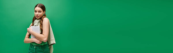 Молодая, красивая женщина в возрасте 20 лет, стоящая в студии, исследуя творческий потенциал яркого зеленого экрана.