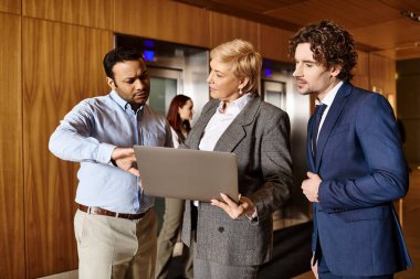 Çeşitli iş grupları dizüstü bilgisayarın etrafında toplandı..