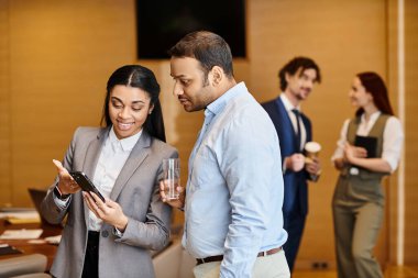 Irklar arası bir erkek ve kadın cep telefonuyla meşgul oluyor..