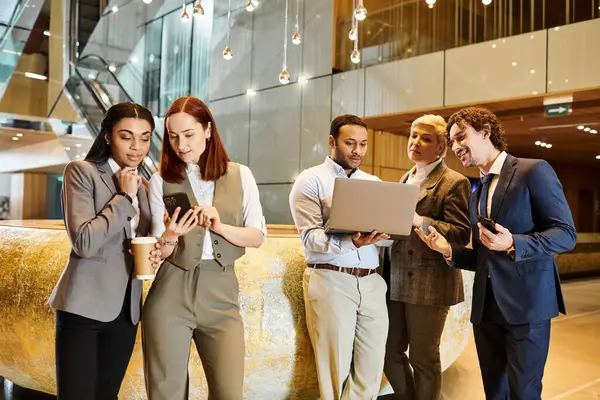 stock image Diverse business team huddling around a laptop, engaged in discussion and problem-solving.