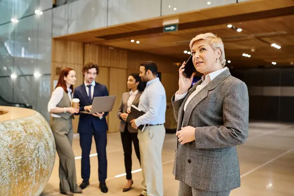 Bir kadın lobide duruyor, telefonla konuşuyor..