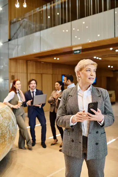 stock image A woman confidently leads an interracial group of business people.
