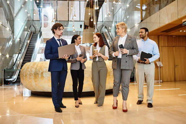 Профессионалы мультикультурного бизнеса собираются в элегантном современном лобби.