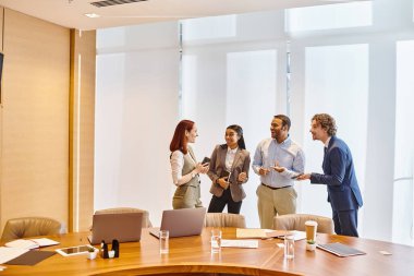 Multicultural business team discuss ideas around conference table. clipart