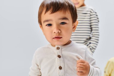 Stüdyoda kardeşinin yanında duran genç bir çocuk, onların ortak varlığı ile samimi bir bağ kuruyor..