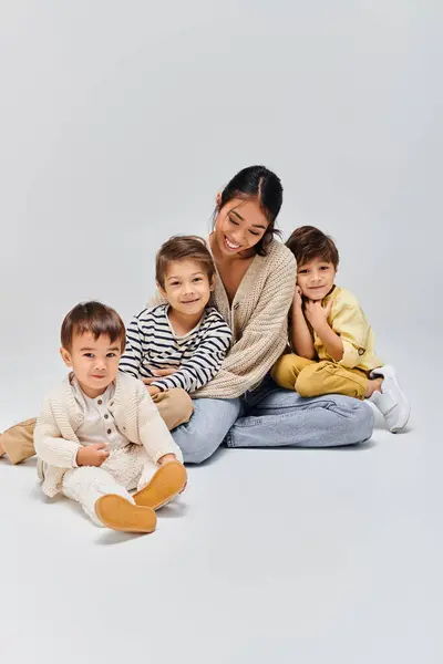 Uma Jovem Mãe Asiática Senta Chão Com Seus Filhos Estúdio Imagem De Stock