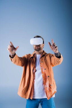 A man wearing a virtual reality headset in a studio setting, exploring the digital world of the Metaverse. clipart