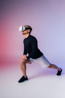 A man in a black shirt and white shorts performs a squat in a studio setting, immersed in a virtual reality experience. clipart