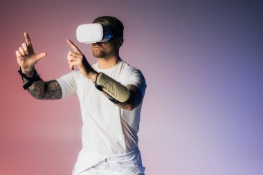 Beyaz gömlekli bir adam stüdyo ortamında Metaverse 'i keşfeden bir çift sanal gözlük tutuyor..