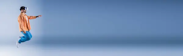 Мужчина Оранжевой Рубашке Синих Штанах Радостно Подпрыгивает Воздухе — стоковое фото