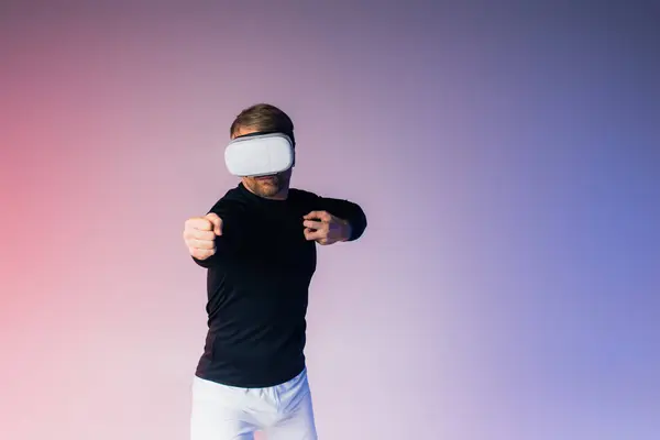 A man, blindfolded, stands before a vibrant pink and blue background in a surreal studio setting.