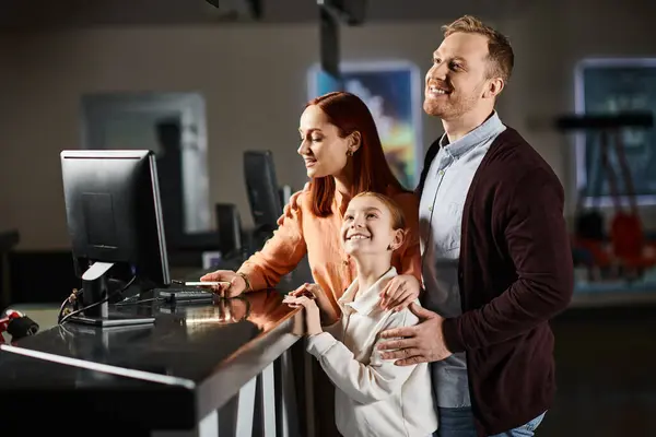 一对夫妇和他们的孩子一起站在电脑前 全神贯注地研究屏幕上的任何东西 在科技上相互联系 — 图库照片