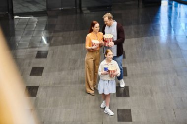 Neşeli bir aile bir arada, sinemada beraberlik anlarını paylaşıyor..