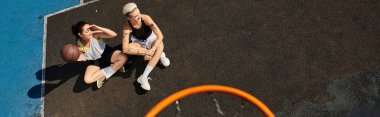 İki genç kadın yaz güneşinin altında canlı bir basketbol maçına çıkıyorlar..