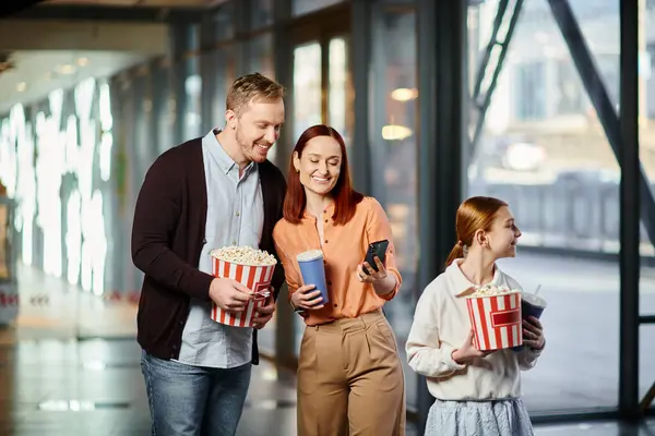 喜んで娘の近くでポップコーンのバケツを握っているカップルは 映画館で一緒に質の高い時間を楽しんでいます — ストック写真