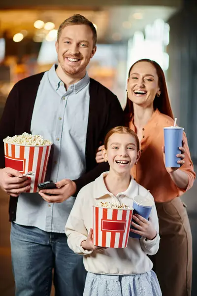 快乐的家人高高兴兴地捧着一桶爆米花 一起在电影院看电影 — 图库照片