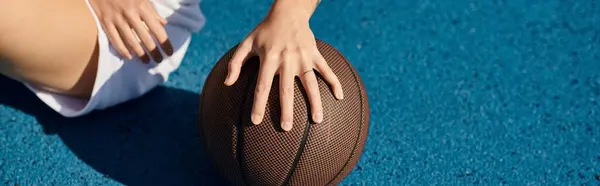 stock image Young woman holding a football outdoors in a close-up shot.