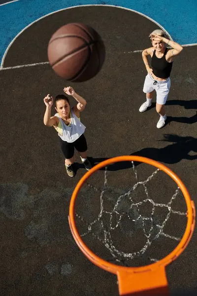 stock image Athletic women conquer the basketball court in a summer showdown.