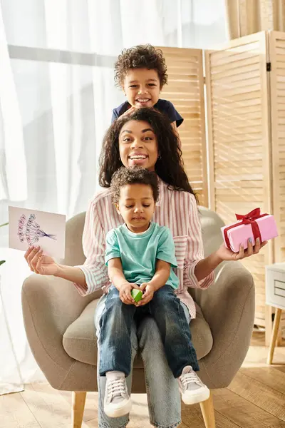 Веселая Африканская Американка Своими Сыновьями Открыткой Подарком Улыбаясь Камеру День — стоковое фото