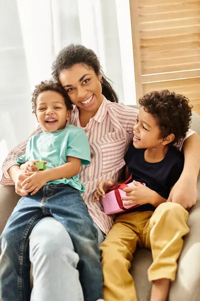 stock image cheerful african american woman smiling at camera and hugging her sons, present, Mothers day