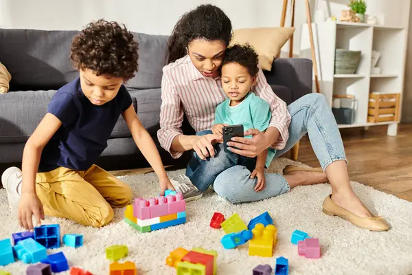 stock image jolly african american mother spending time with her adorable sons and holding phone in hands