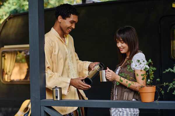 A man and a woman stand on a balcony, admiring the breathtaking view ahead of them on a romantic getaway.