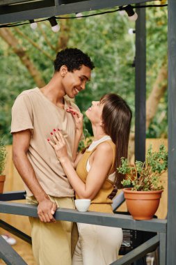 An interracial couple stands together, embracing in front of a camper van, symbolizing love and companionship on a romantic getaway. clipart