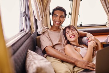 A man and woman sit side by side on a train, gazing out the window as they travel together on a romantic adventure. clipart