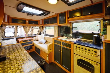 cozy kitchen and living area in recreational vehicle for a romantic getaway. clipart