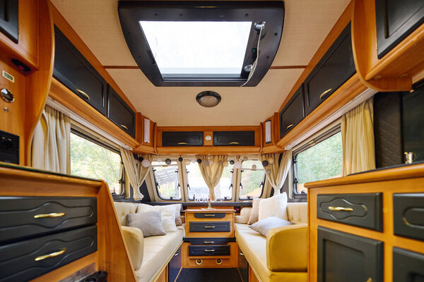 camper van with comfortable couches and large windows offering scenic views.