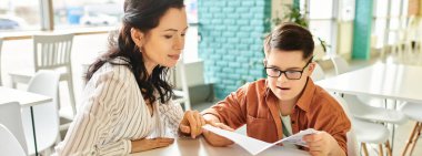 loving jolly mother sitting in cafe with her inclusive son with Down syndrome holding menu, banner clipart