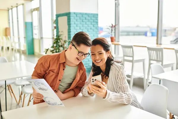 stock image beautiful woman in casual clothes in cafe with her inclusive son with Down syndrome holding menu