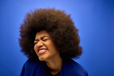 Smiling African American woman with curly hairdoin stylish blue jacket. clipart