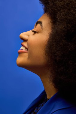 Hareketli bir arka plana karşı şehvetli bir afro pozu veren şık bir Afrikalı Amerikalı kadın..