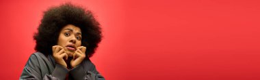 Şehvetli afro saçlı bir kadın komik bir yüz ifadesi takınıyor..