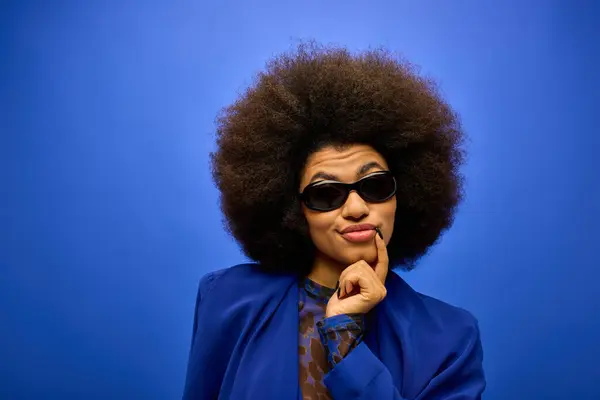 African American Woman Sunglasses Blue Jacket Poses Vibrant Backdrop — ストック写真