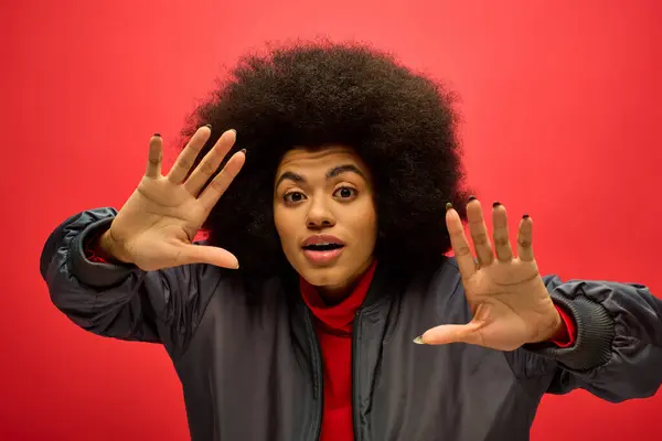 stock image African american woman with curly hairdoholding his hands up in a powerful gesture.