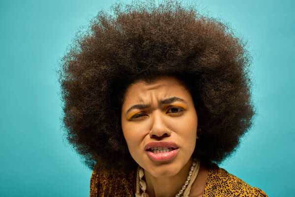 A stylish African American woman in trendy attire, with curly hairdohairstyle, looks surprised.