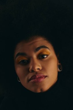 Hareketli bir arka plana karşı şehvetli bir afro saçı olan şık Afrikalı Amerikalı bir kadının yakın çekimi..