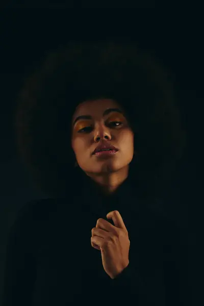 暗闇に立っているカーリーヘアのファッショナブルなアフリカ系アメリカ人女性 — ストック写真